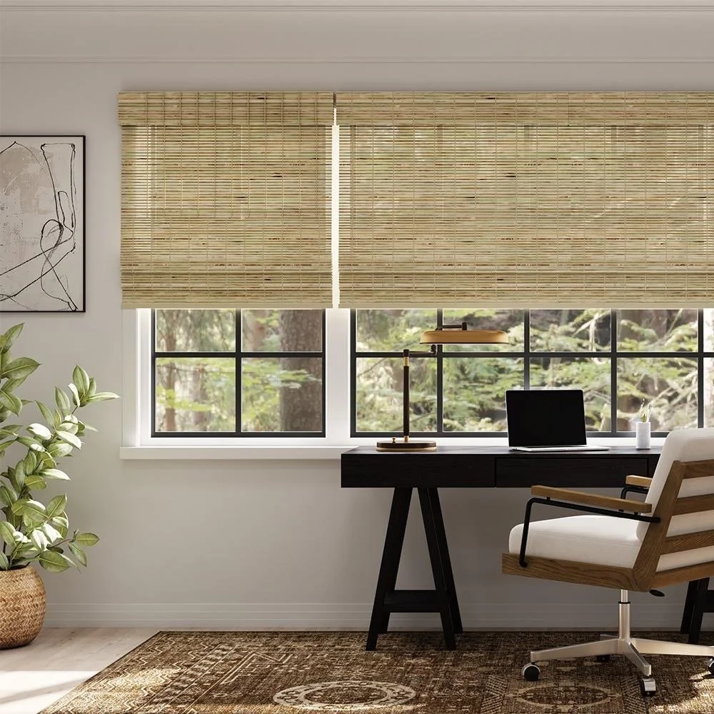 Home office with a black desk, white ergonomic chair, potted plant, and two windows with bamboo blinds allowing natural light.