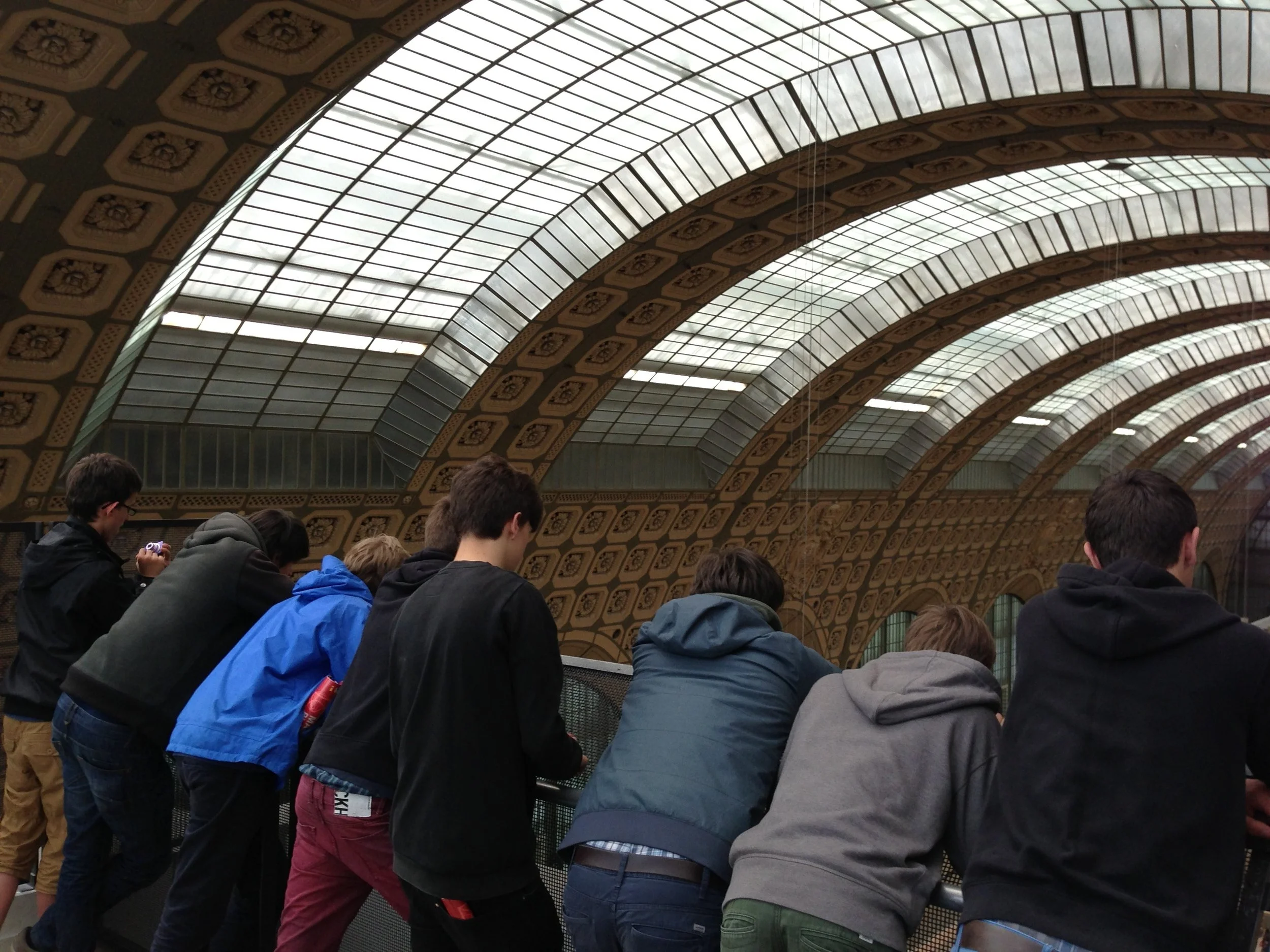 A group of boys staring out at a train station from above