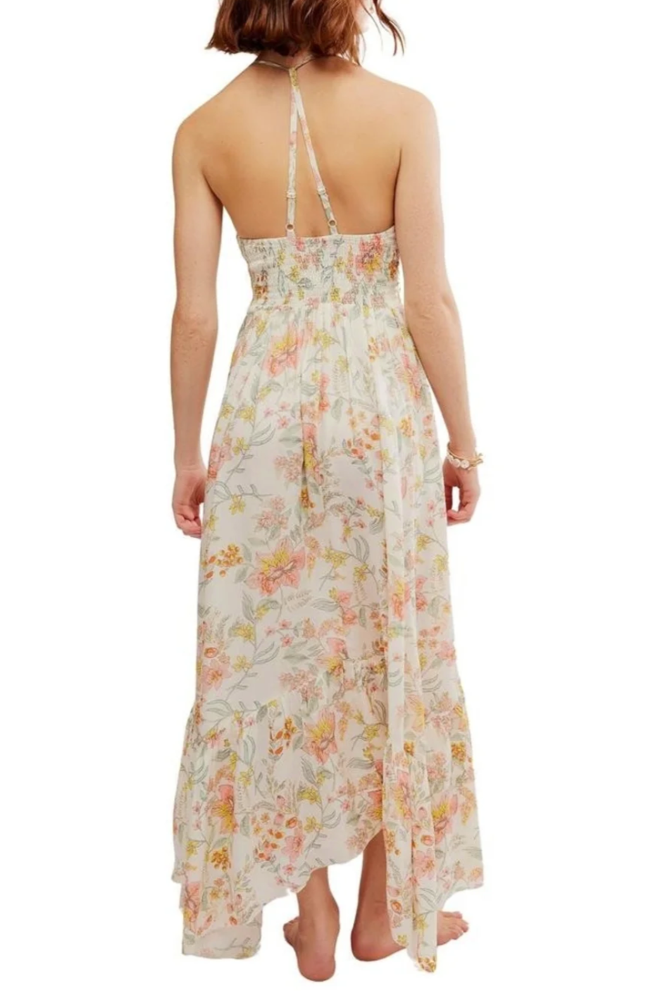 Back view of a woman wearing a sleeveless floral maxi dress with spaghetti straps and a slit on the side.