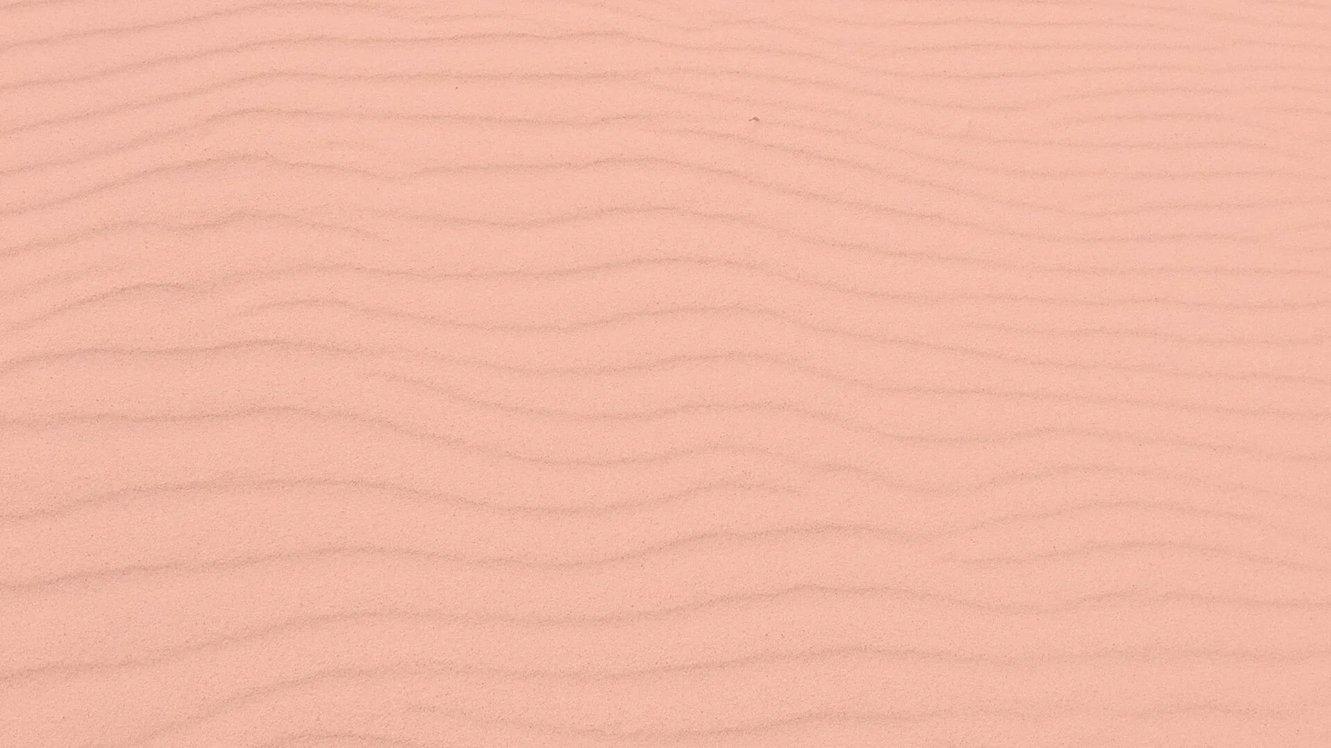 A close-up of a light pink wooden surface with subtle wood grain texture.