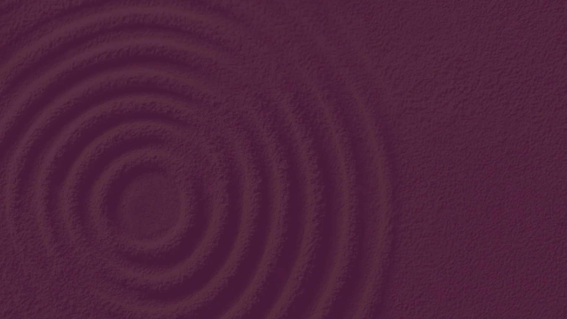 Close-up of a burgundy surface with concentric circular ridges.