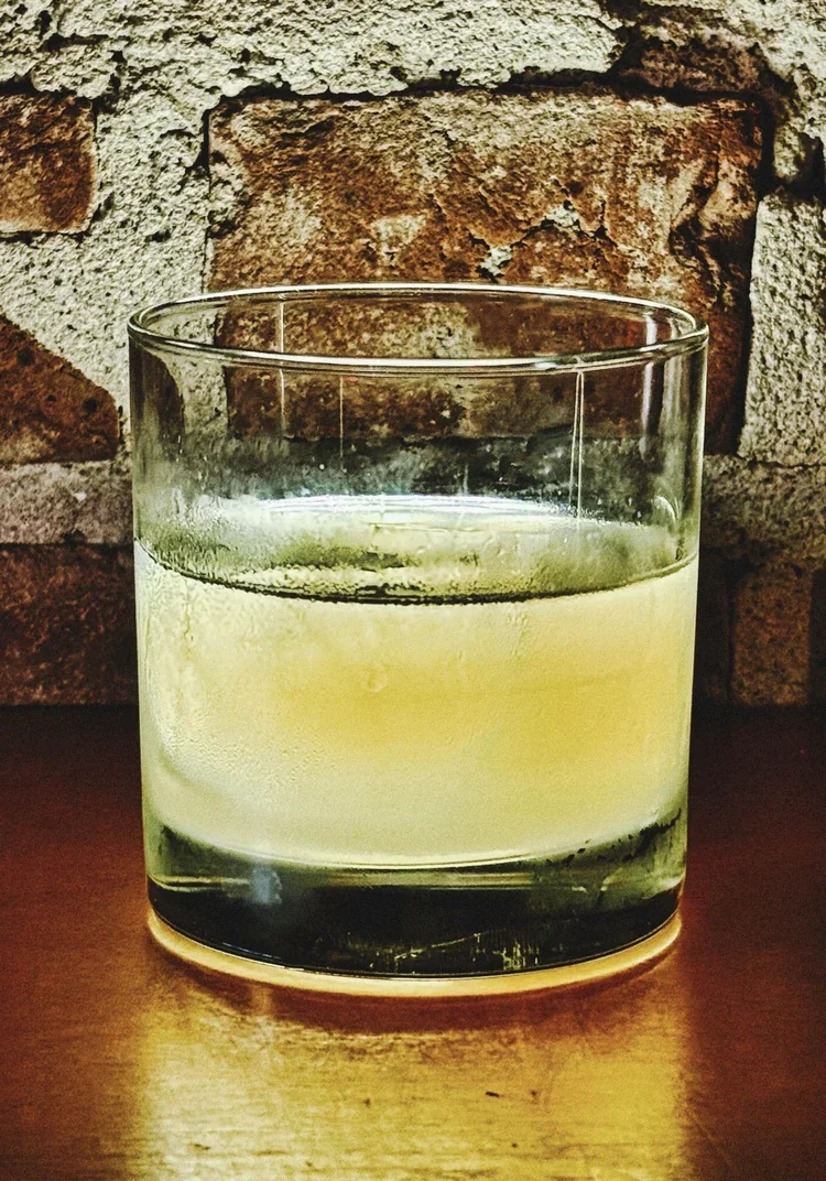 Gin cocktail in highball glass with lemon.