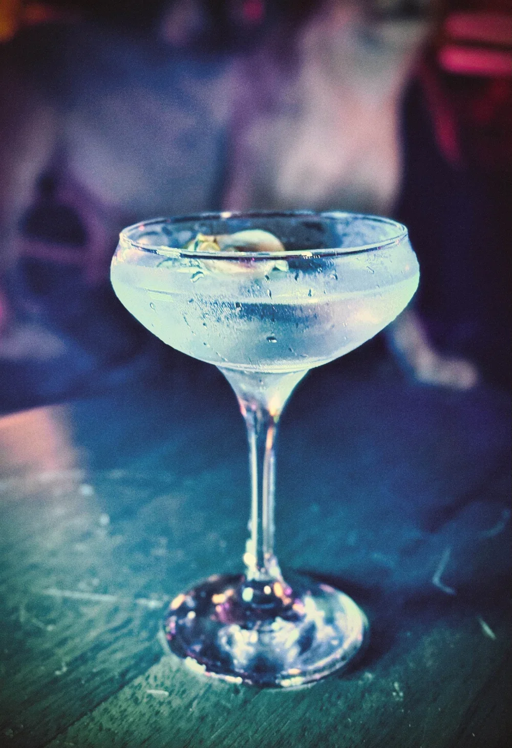 Cocktail in a coupe glass with a dried apple garnish.