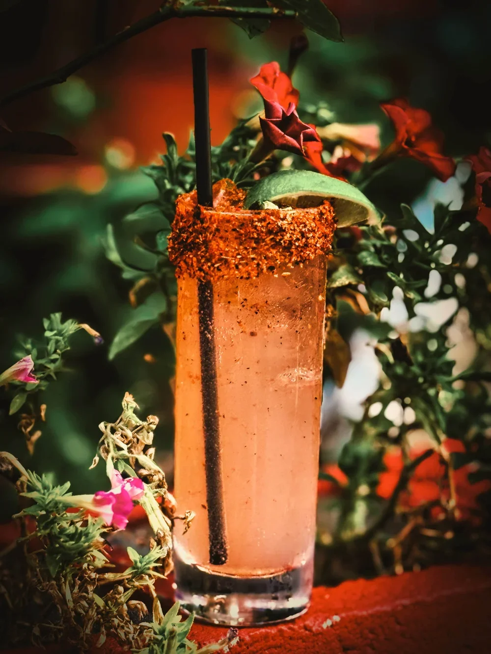 Amber colored cocktail in a tail glass with a lime and jalapeno.