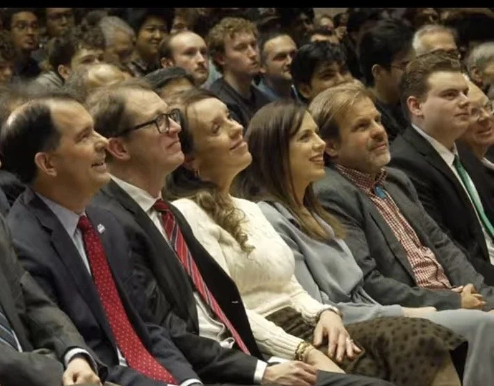 Luke-Smith seen seated next to Governor Scott Walker where Wisconsin leaders are seen together again