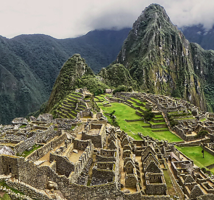 Ancient Incan city of Machu Picchu with stone structures and terraces amid lush green mountains.