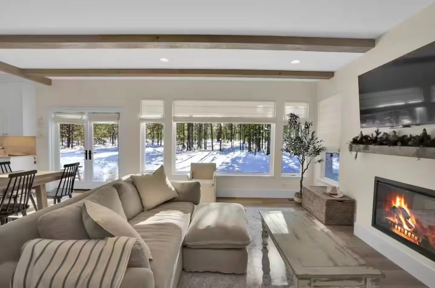 Living room with large windows looking out on snowy pines