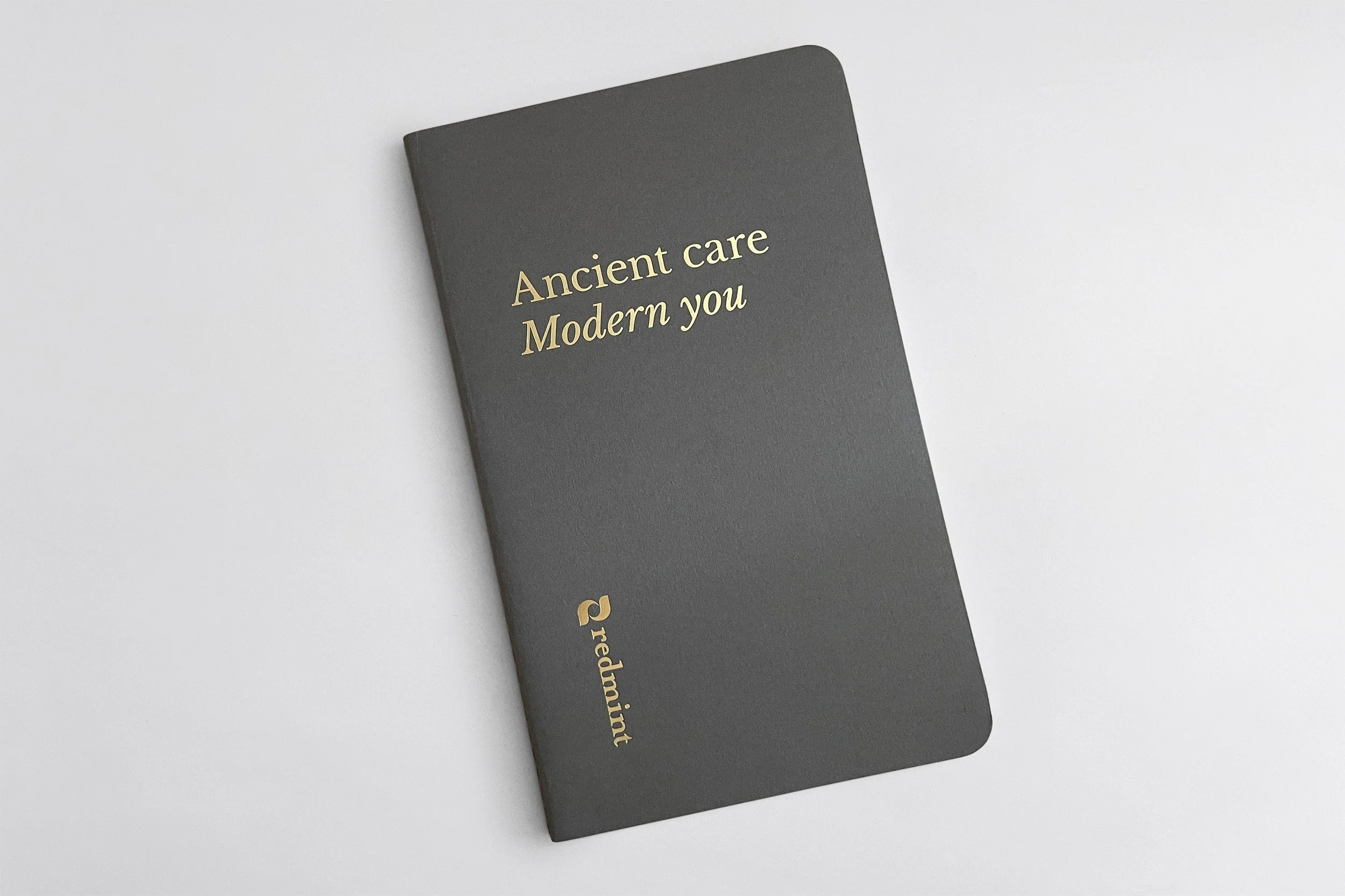 gold foil printing logo tagline on gray notebook