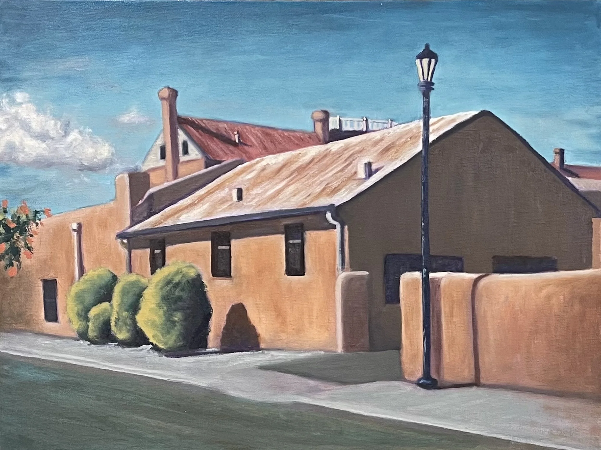 A painting of a building with peach-colored walls and a red roof, with a dark streetlamp and green bushes in the foreground, under a bright blue sky with white clouds.