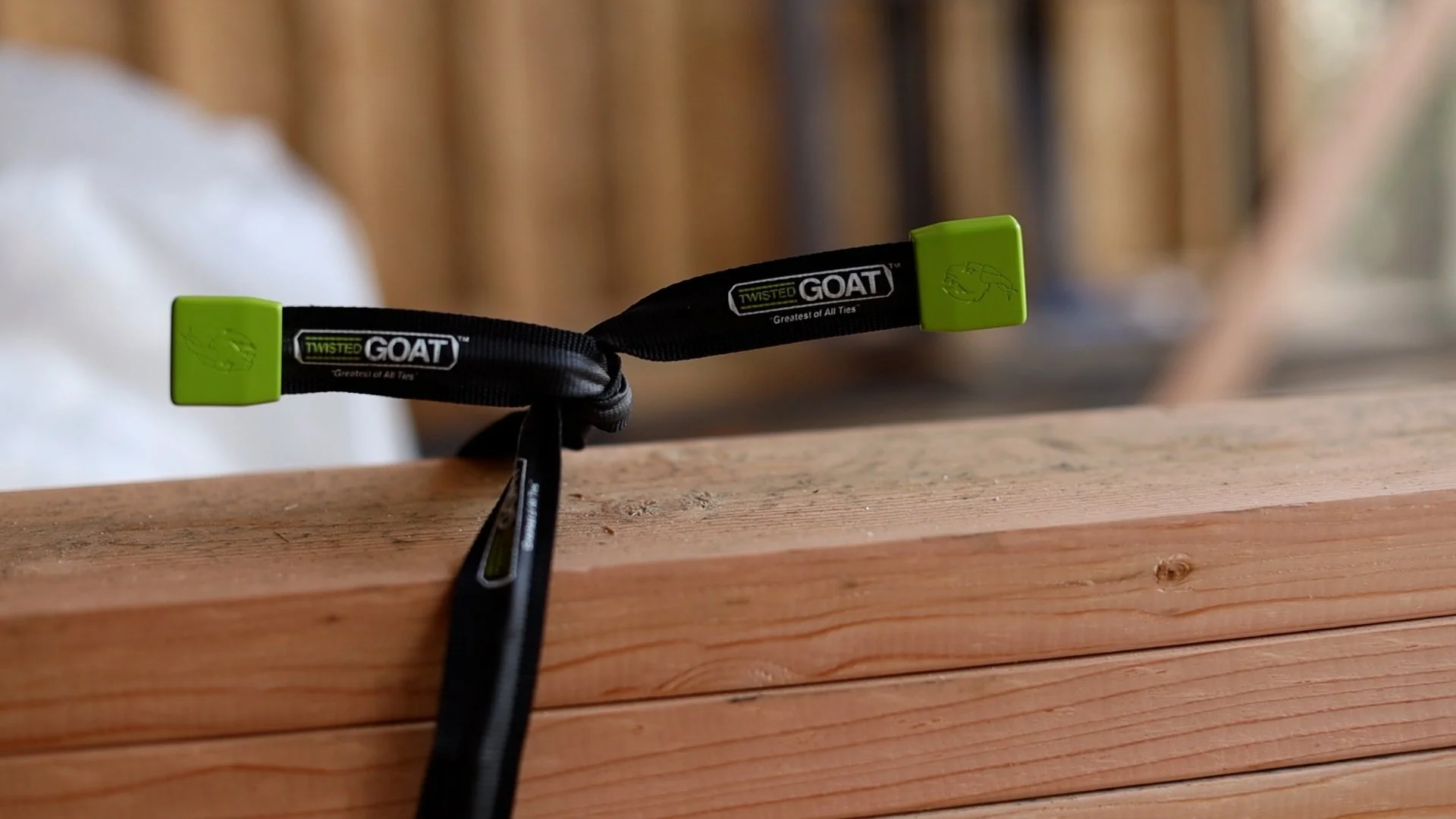 A black and green Goaty twist tool with a logo on the strap, resting on a wooden surface.