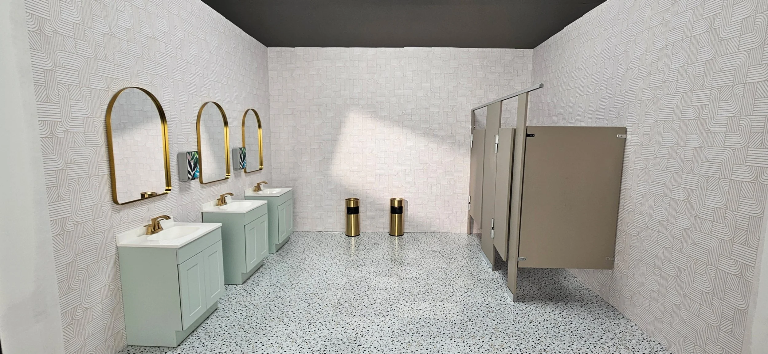 Custom built set on soundstage made by Daedallus LLC as part of the Art Department.  Public restroom with three sinks, three mirrors with gold frames, and two gold trash bins, with terrazzo floors and patterned wallpaper.