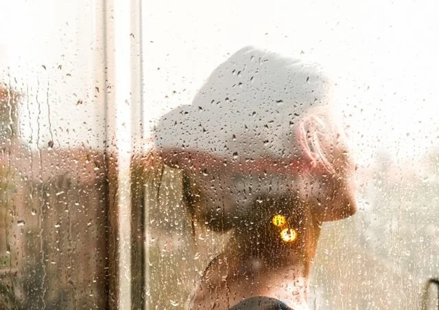 woman seen through rain soaked window