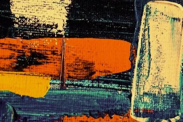 Close-up of an abstract painting with bold brushstrokes in orange, yellow, black, green, and blue colors.