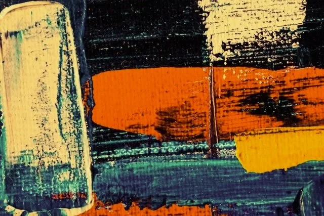 Close-up of an abstract painting with blue, orange, yellow, and black colors.