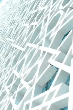 Close-up of a white decorative wall with an intricate geometric pattern.