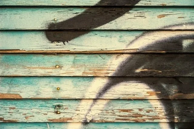 spray painting on blue peeling wood