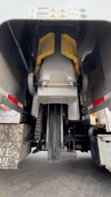 Back view of a large construction vehicle showing the tracks, hydraulic system, and rear section