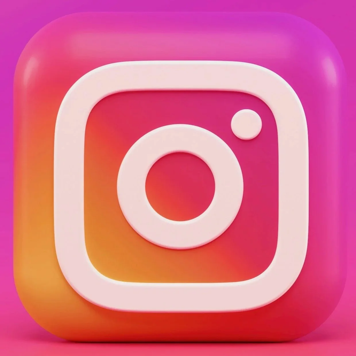 Instagram logo with a 3D design on a pink and orange gradient background.