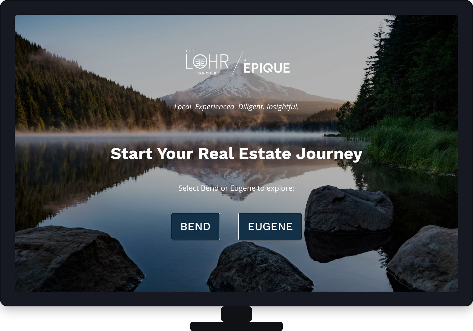 Website homepage for real estate company featuring a lake with rocks in the foreground, evergreen trees, and a mountain in the background, with overlay text about starting a real estate journey and options to select Bend or Eugene.