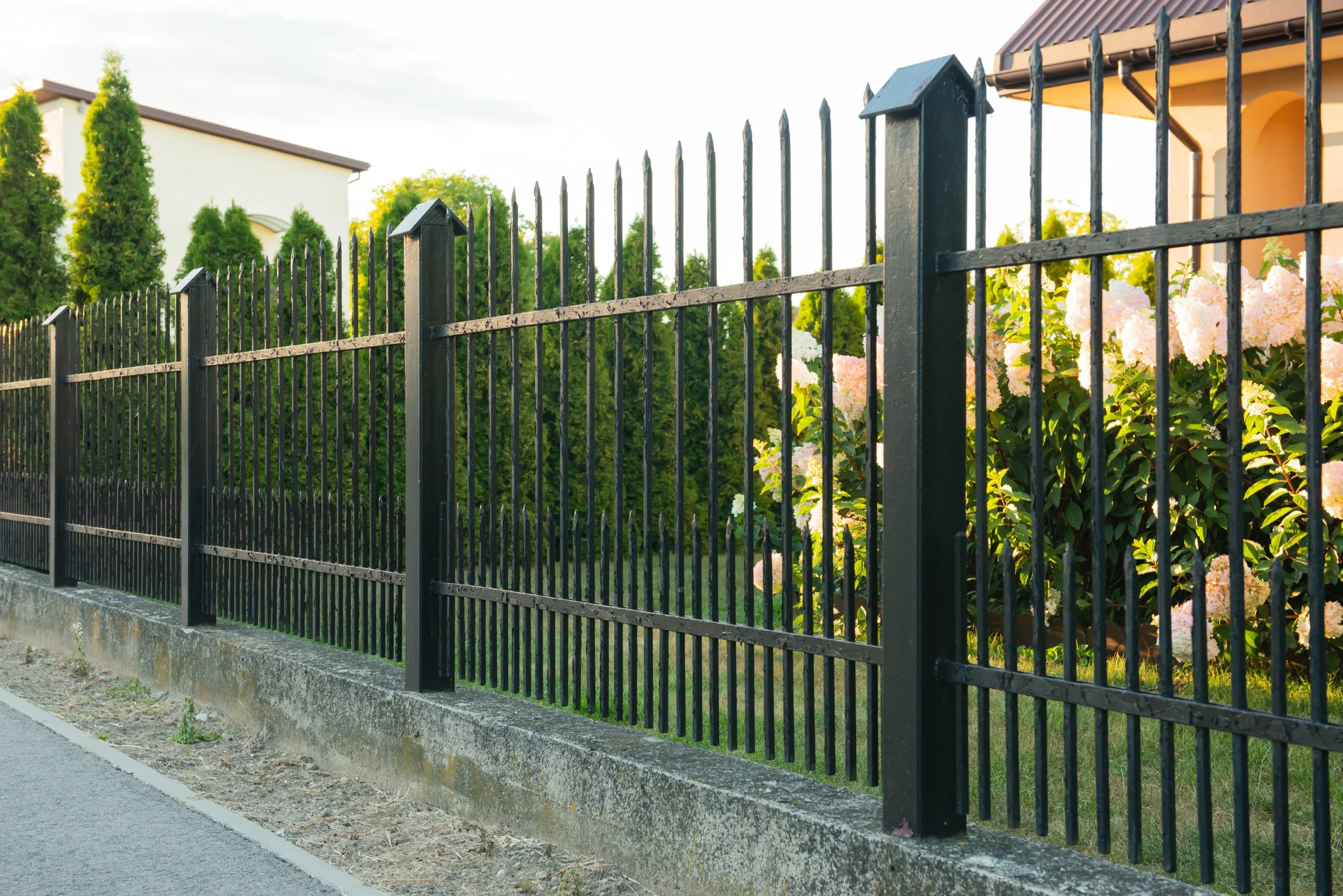 black-metal-wrought-iron-fence-around-a-suburban-h-2026-05-11-15-59-44-utc.jpg
