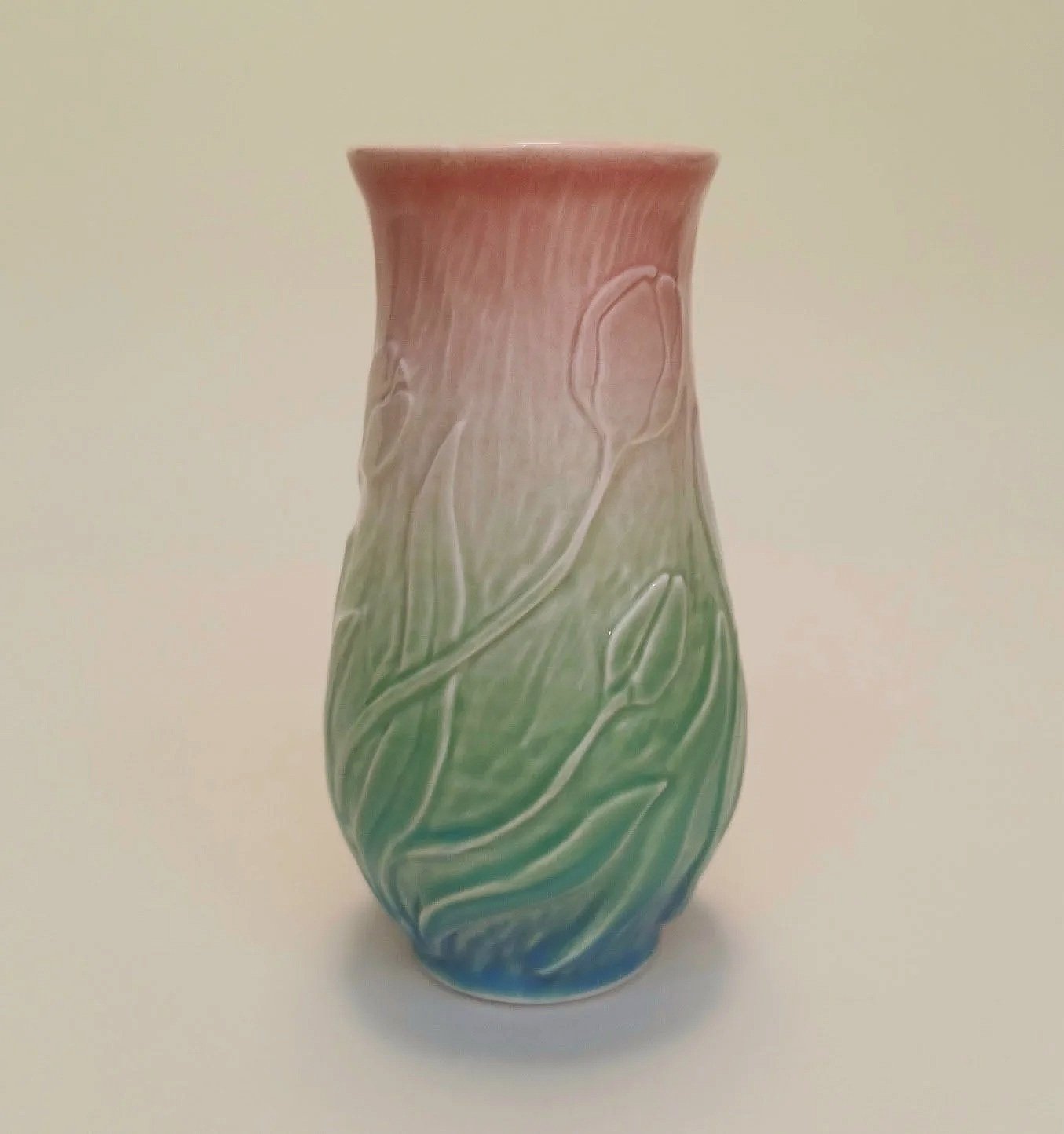 Rainbow ceramic vase with pink, green, and blue hues, decorated with flowing tulip patterns.