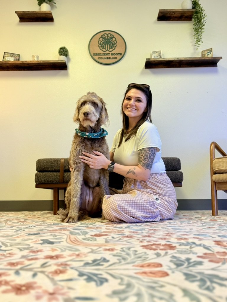 Adriana "Gabbi" Ascencio with her therapy dog in the Resilient Roots Counseling office