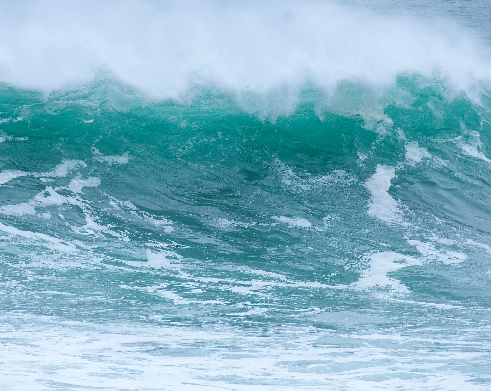 Ocean waves, turquoise water, and white sea spray.
