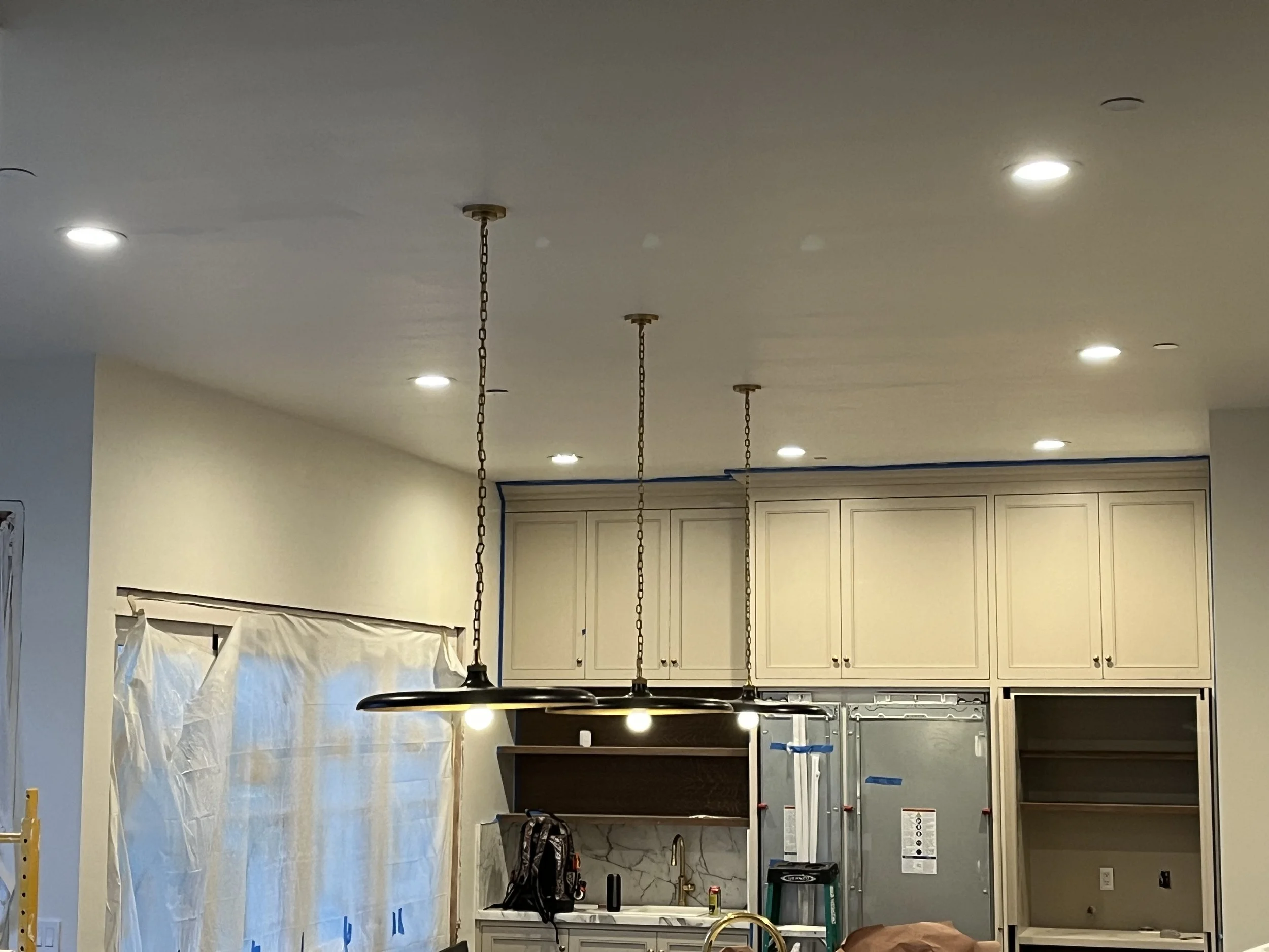 Newly installed kitchen ceiling recessed lights and hanging pendant lights