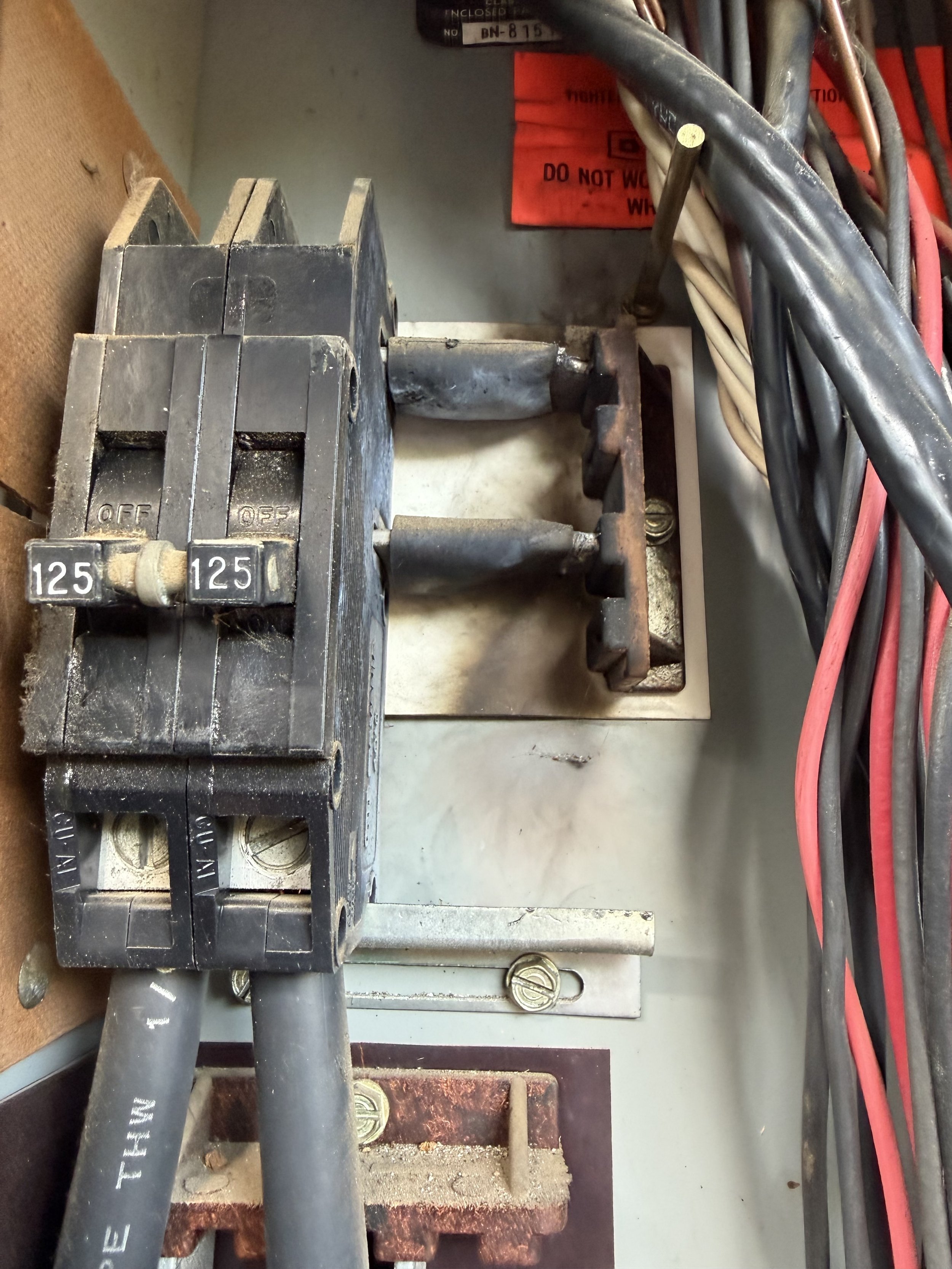 Rusted panel interior showing corrosion and fire hazard