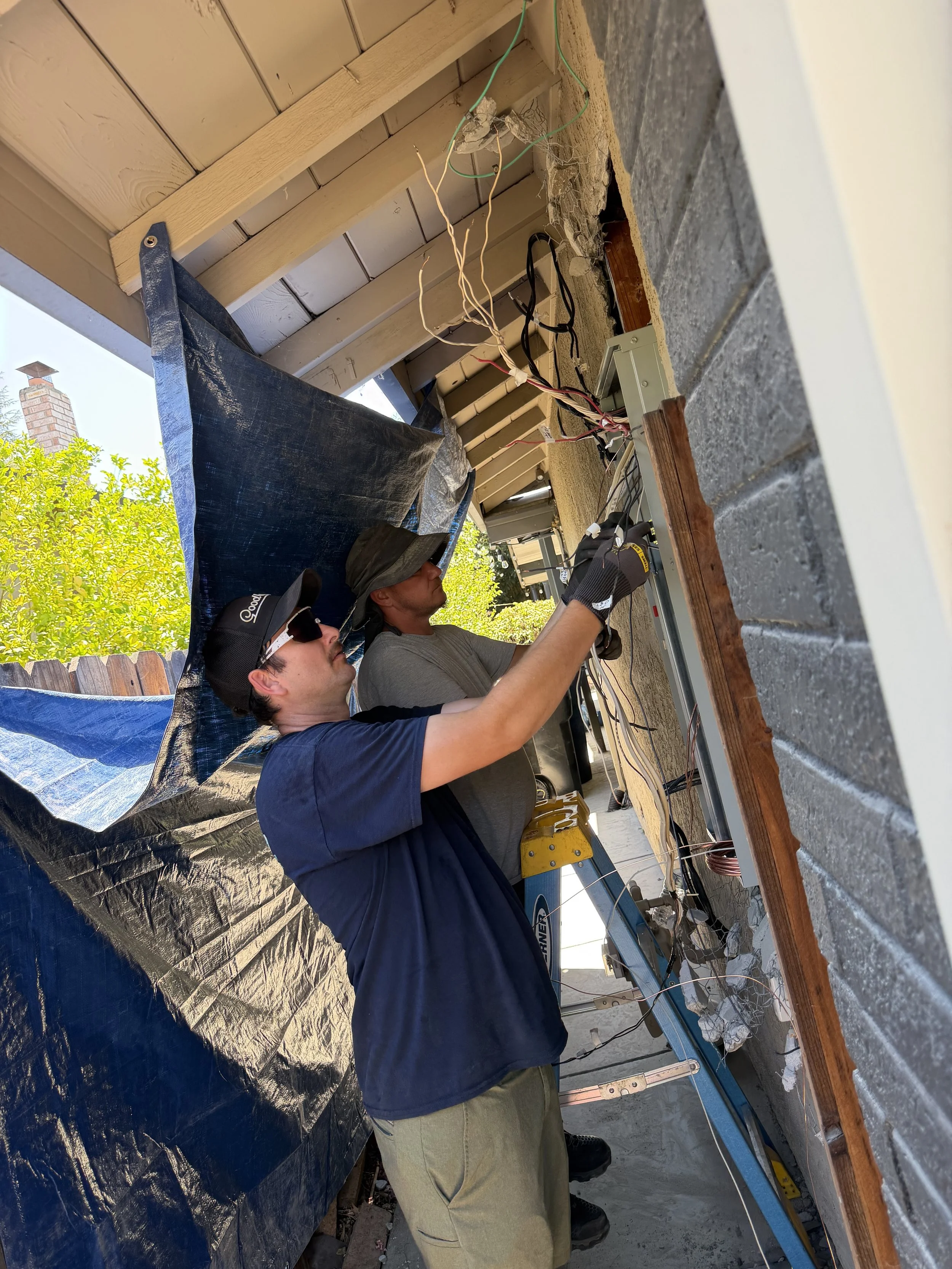 Boost workers Steve and Sam installing electrical wiring for a panel upgrade.