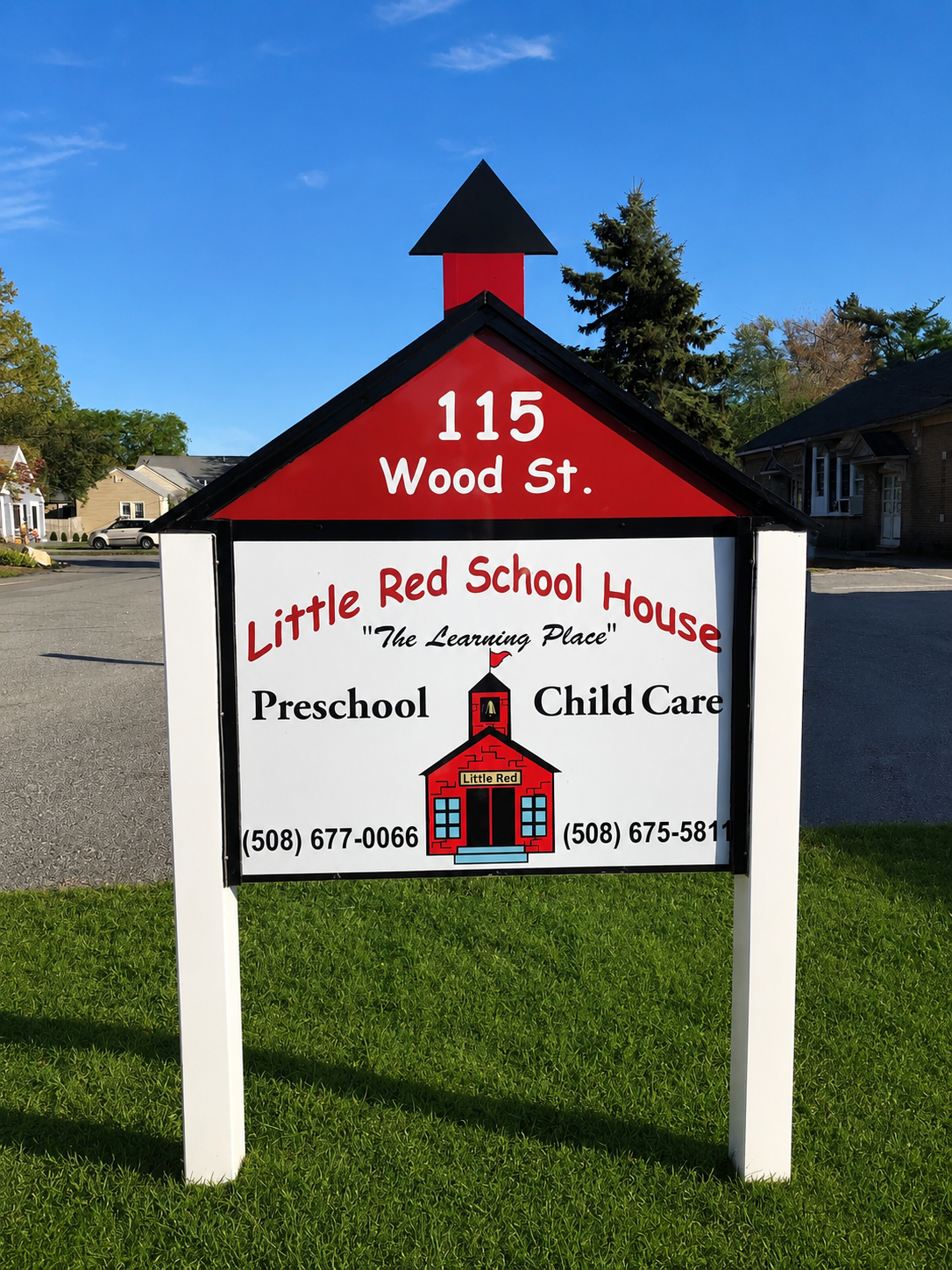 Sign for Little Red School House at 115 Wood Street, featuring a red schoolhouse graphic, with contact numbers, and includes preschool and child care services.
