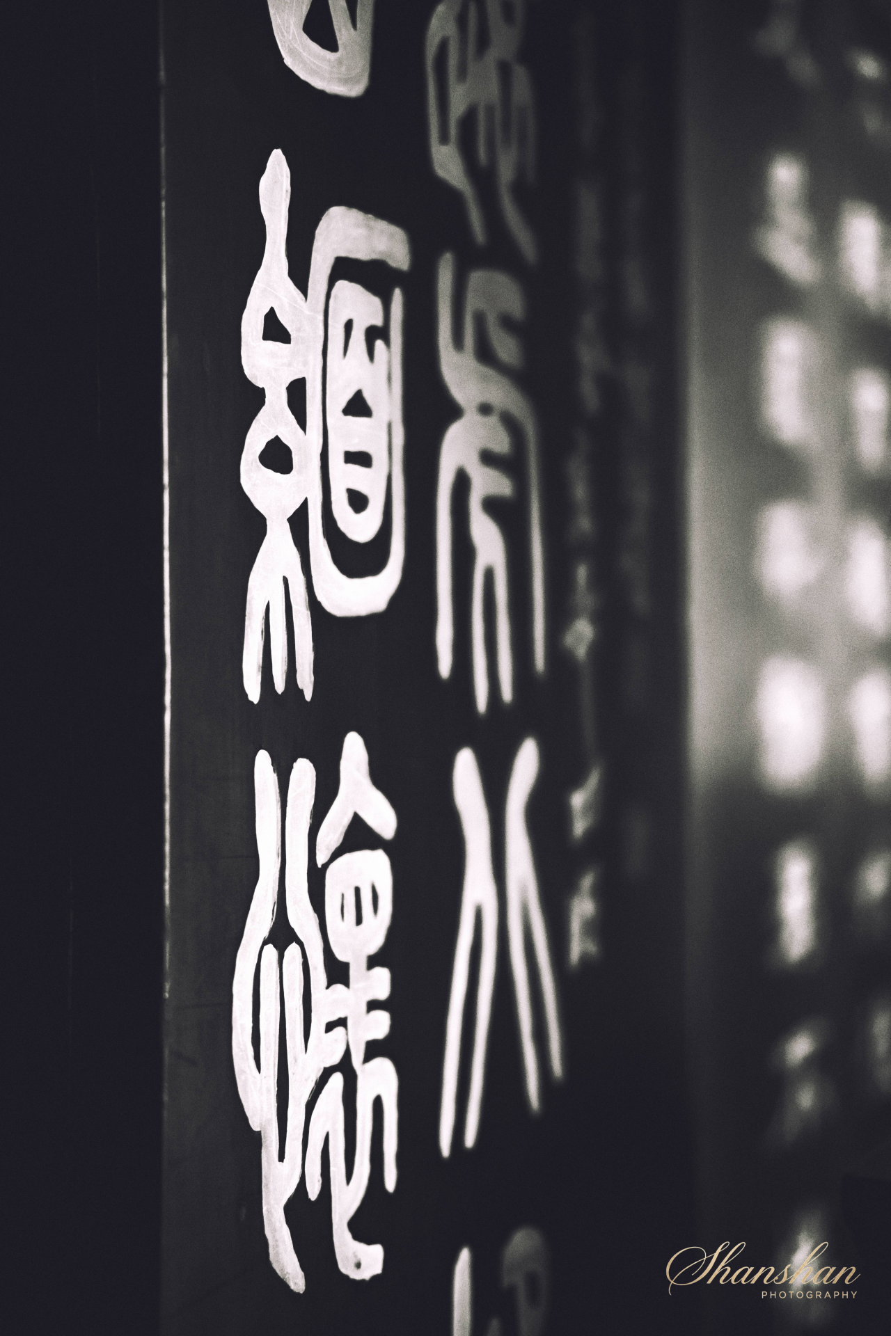 Black surface with white stick figure illustrations of a man and woman standing side by side, with some Chinese characters at the bottom, and light reflections in the background.