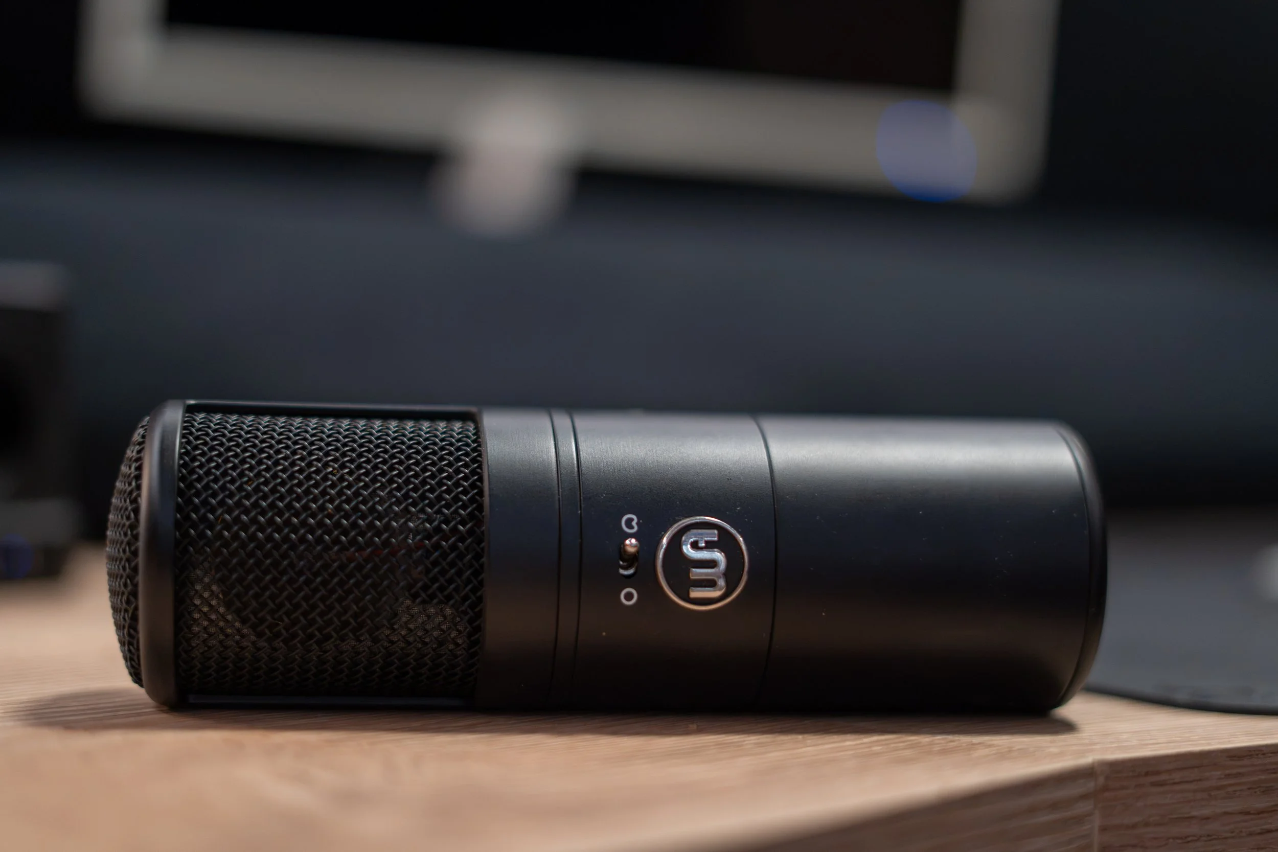 Microphone noir placé sur une table en bois