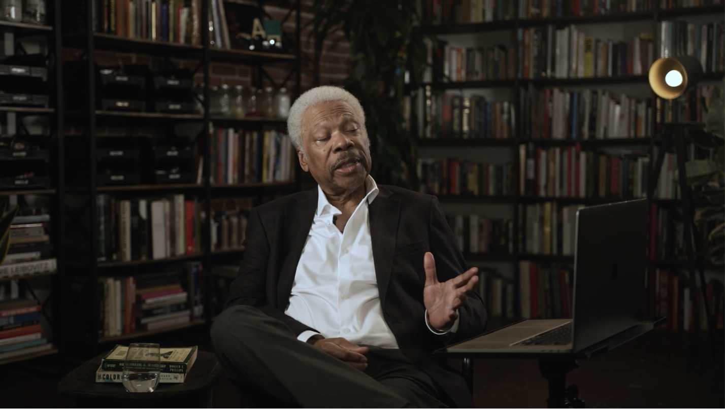 Ernest L. Jarrett teaching Mastering the Courtroom from a seated interview setting surrounded by books.