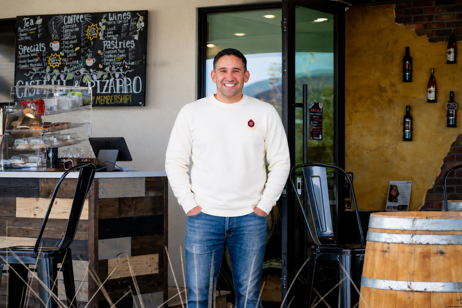 Nelson Pizarro Founder of Banking For Legacy is standing in front of his coffee and wine bar using his Infinite Banking Concept to the store.