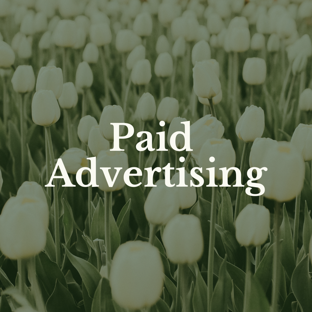 The text 'Paid Advertising' over white flowers in a field with green stems.