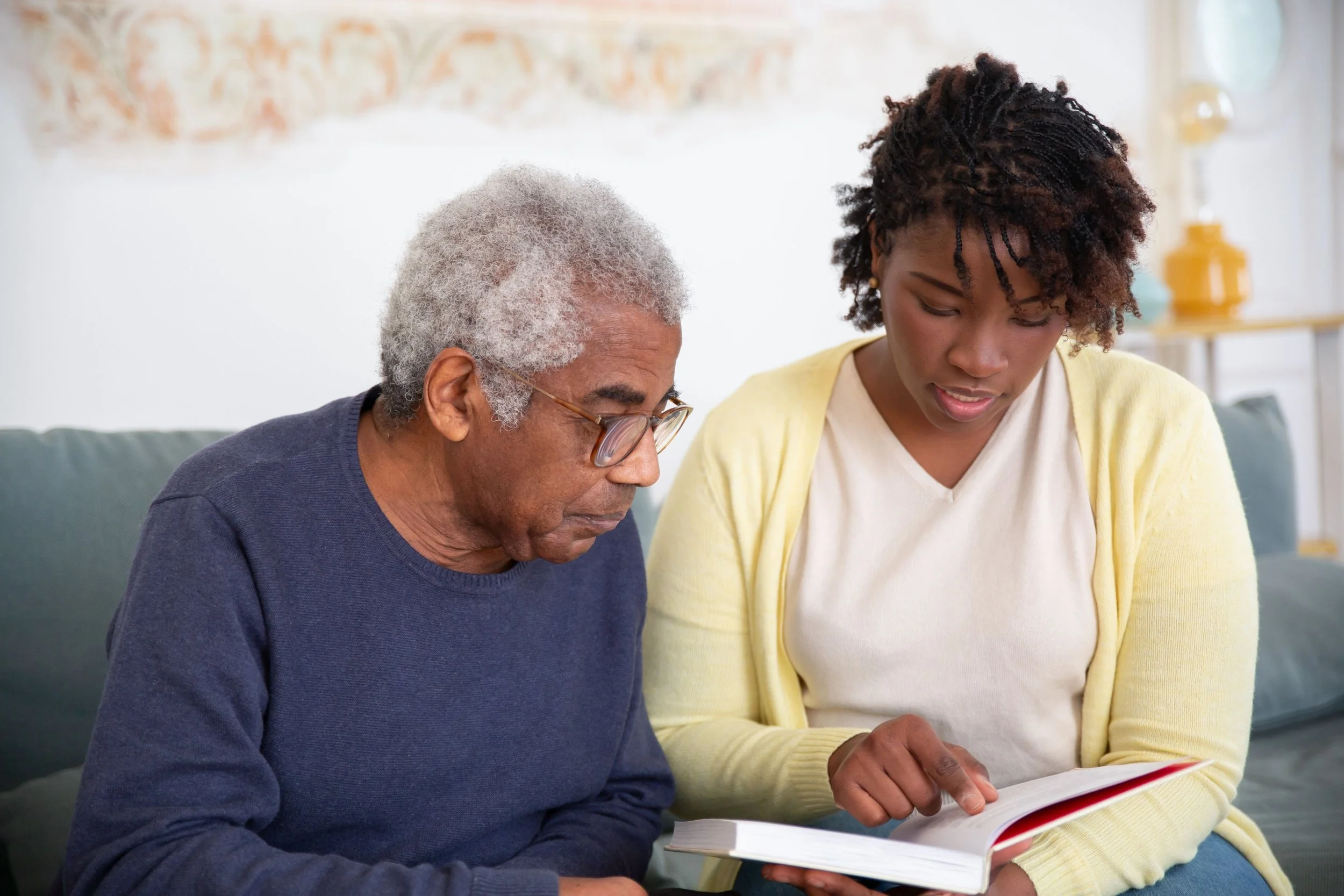 A care working reading to an elderly adult