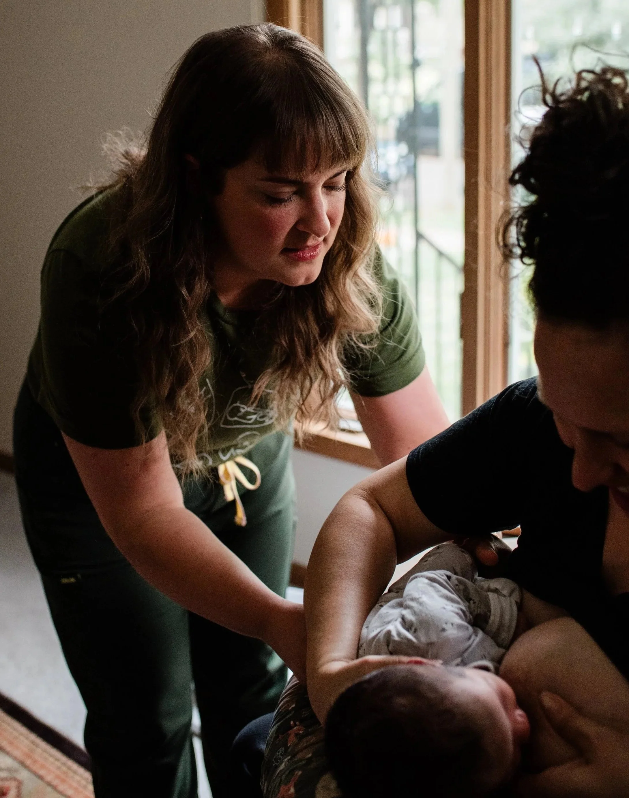 Kayla supporting a parent and baby during breastfeeding at home