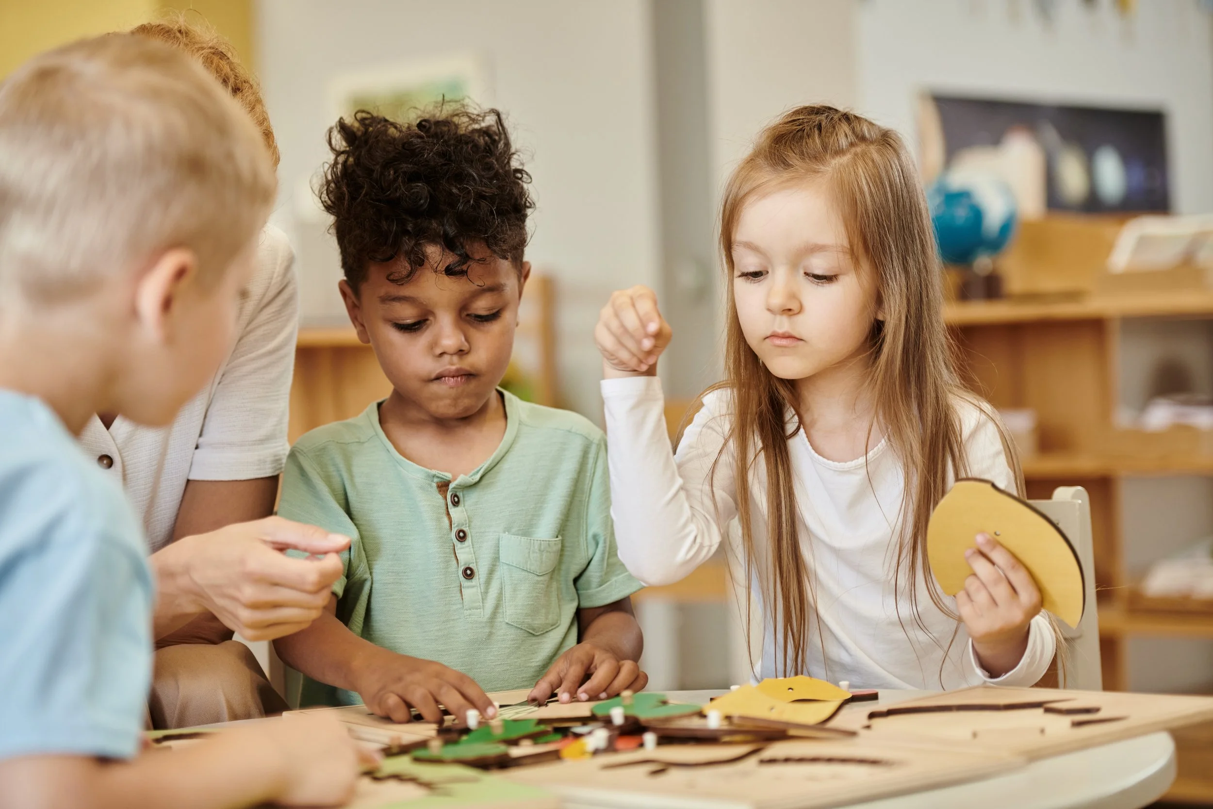 Children and an adult playing a board game together at a table.