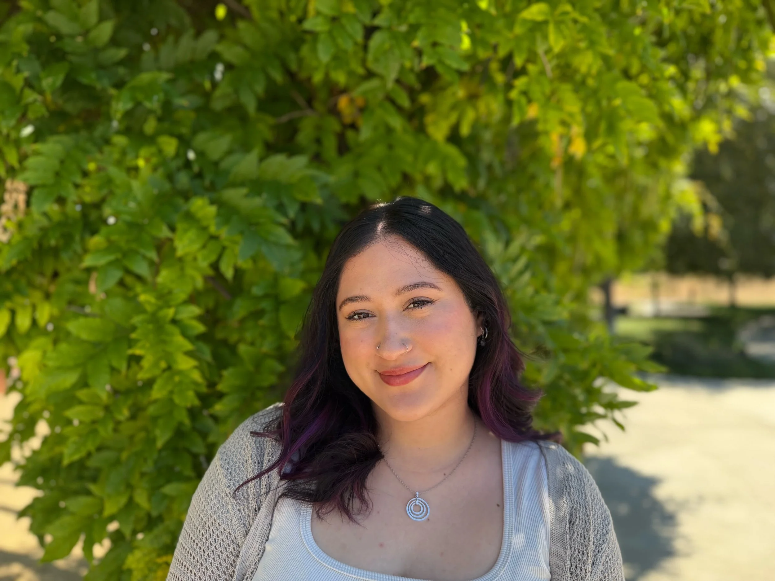 Mariana Gonzalez, LMFT, a virtual therapist in California, smiling outdoors in a light gray cardigan.