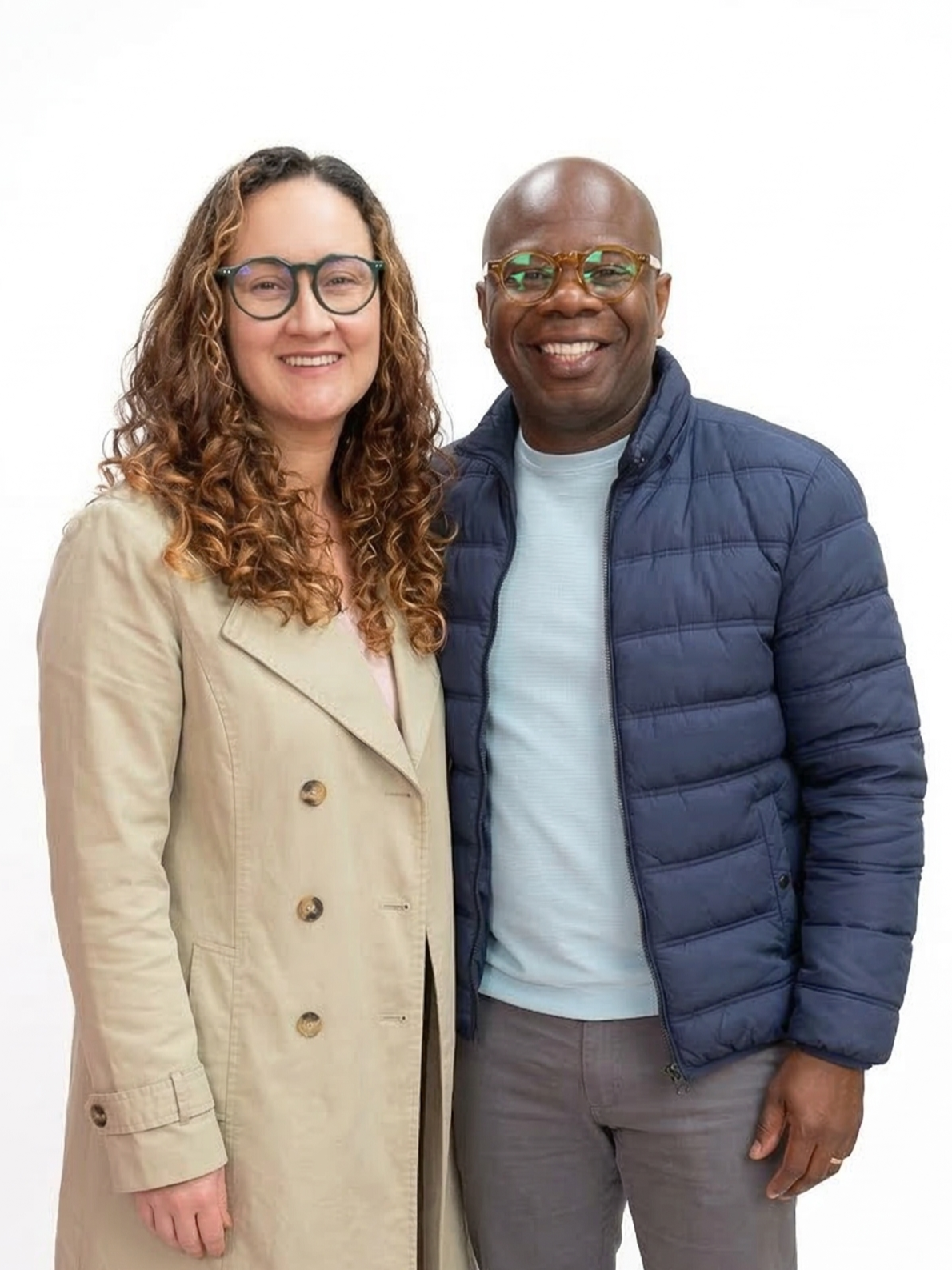 Hombre y mujer sonriendo y posando juntos en un fondo blanco.
