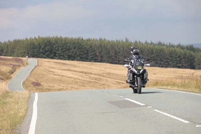 A person riding a motorcycle on an open countryside road.
