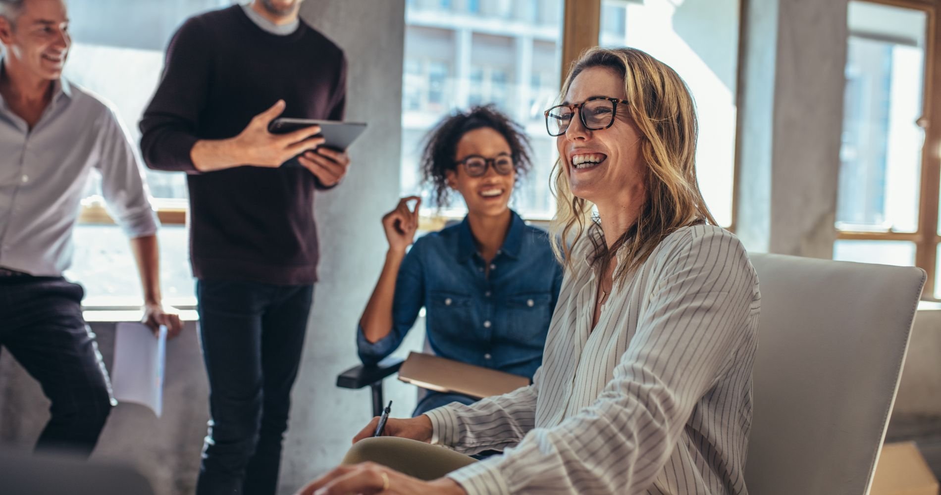 Fröhliches Meeting im Büro mit Frau in den Wechseljahren
