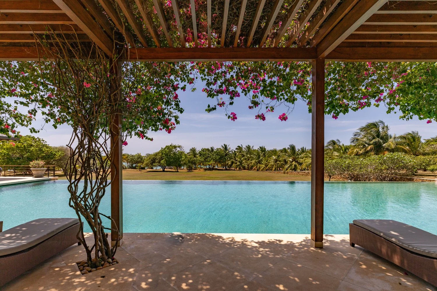 Wooden pergola overlooking the 33-metre infinity pool and gardens at Ranawara Villa, Sri Lanka