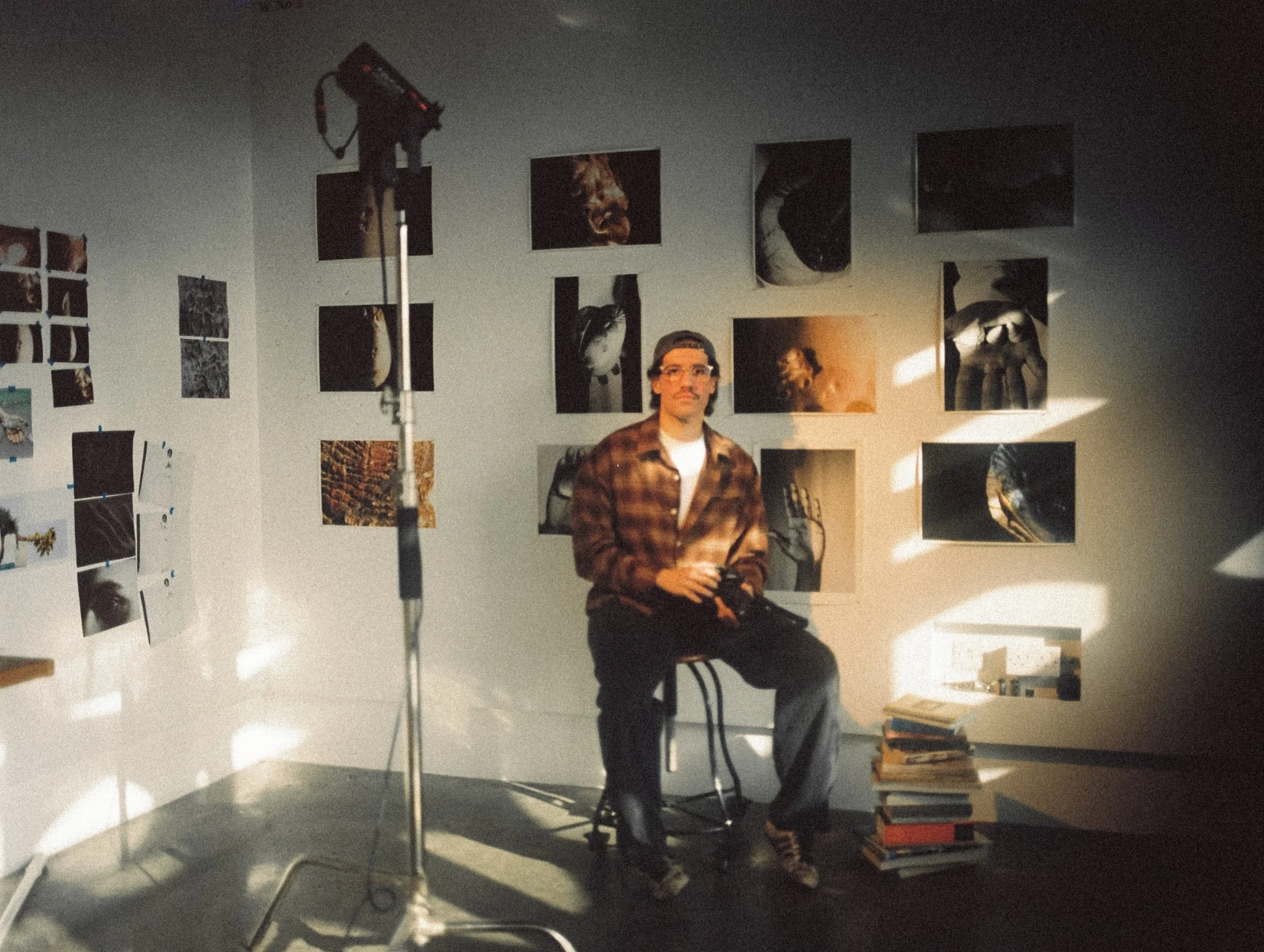 Qatari photographer Hamad AlFayhani in the studio at Doha Fire Station in front of photographs of the Gulf.