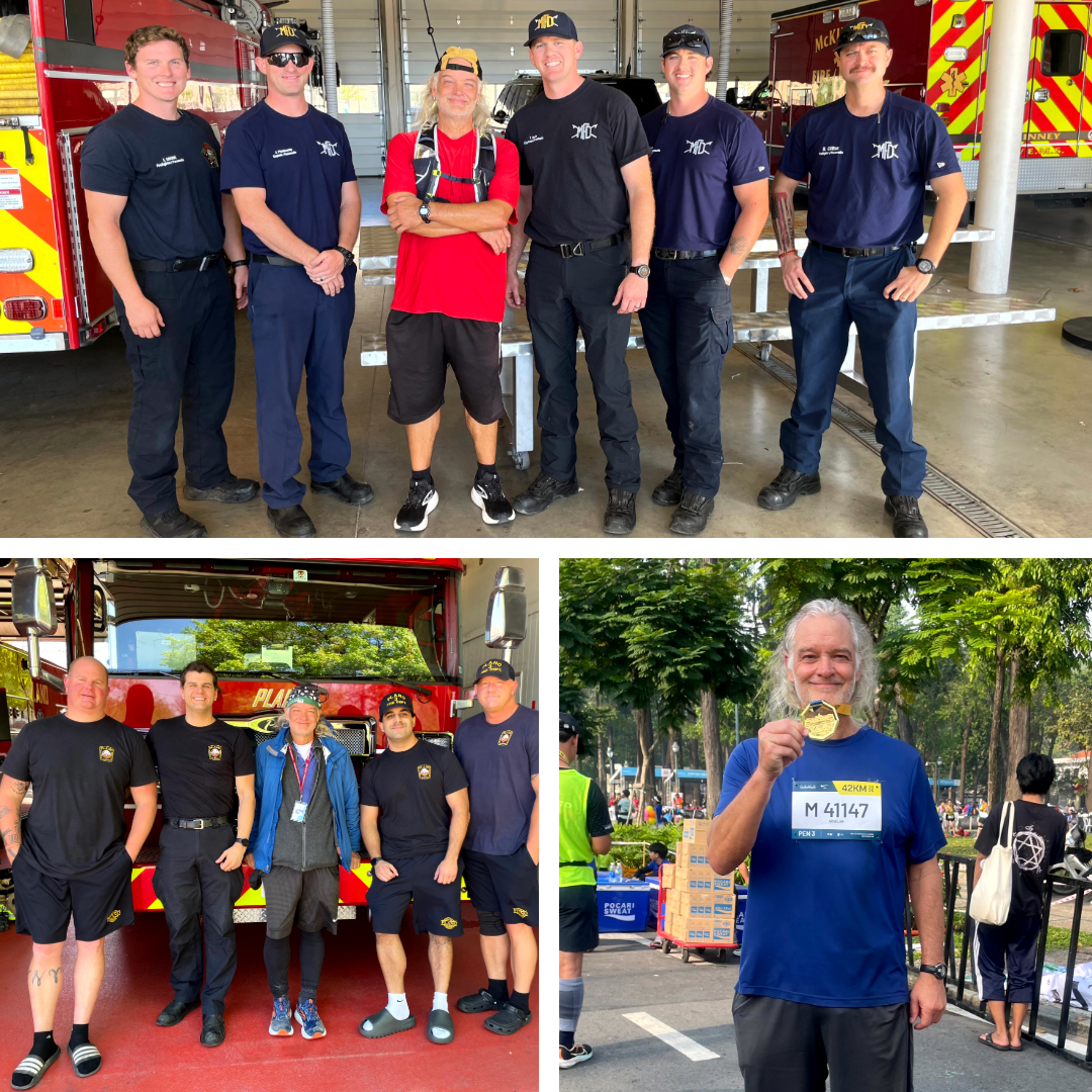 Ultramarathoner JT Shull wearing running gear, standing between two groups of firefighters and first responders with fire trucks in the background, holding a medal after completing a running event
