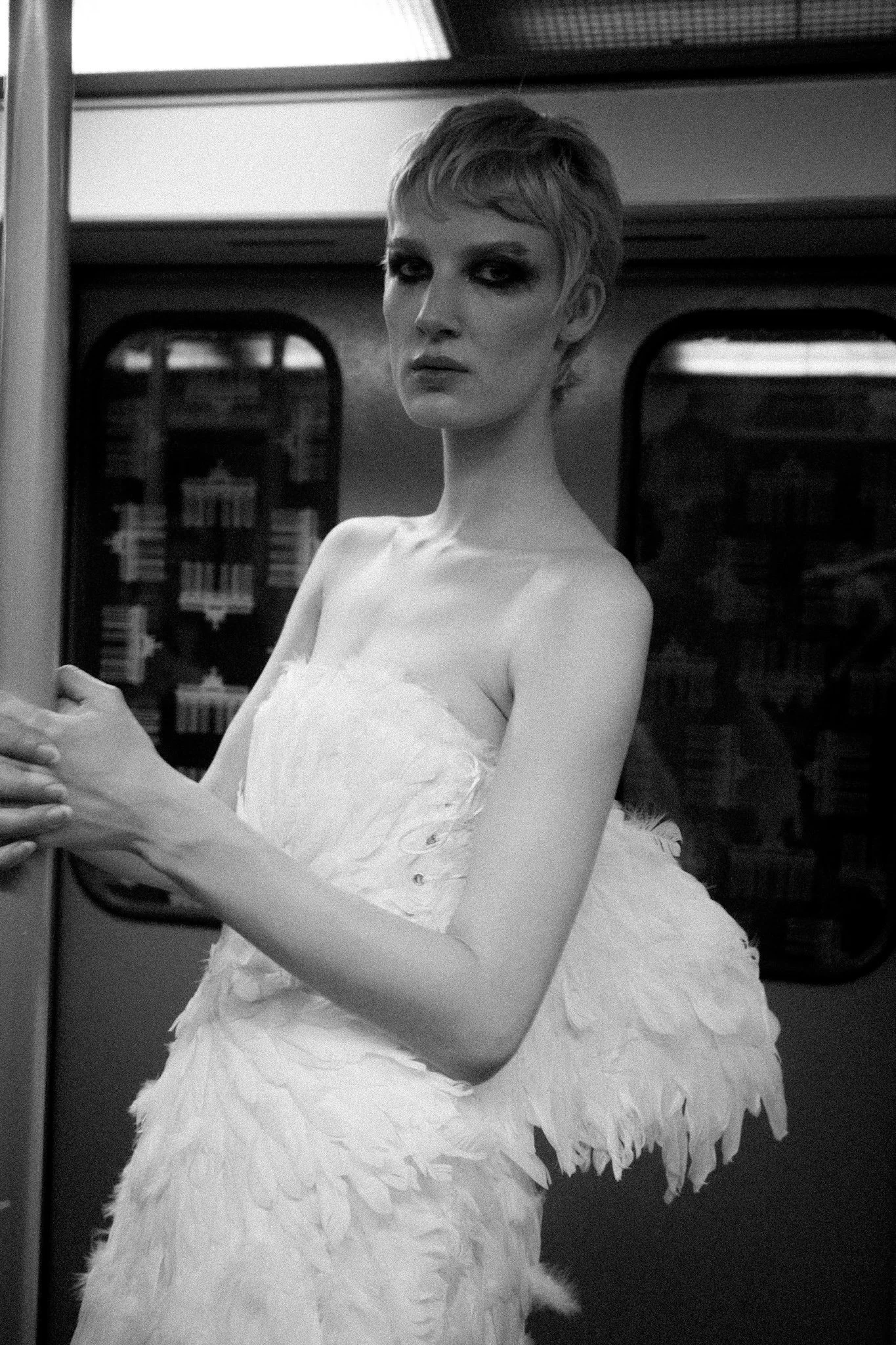 Portrait of a woman wearing a winged dress in the Berlin subway. Black and white fashion photography.