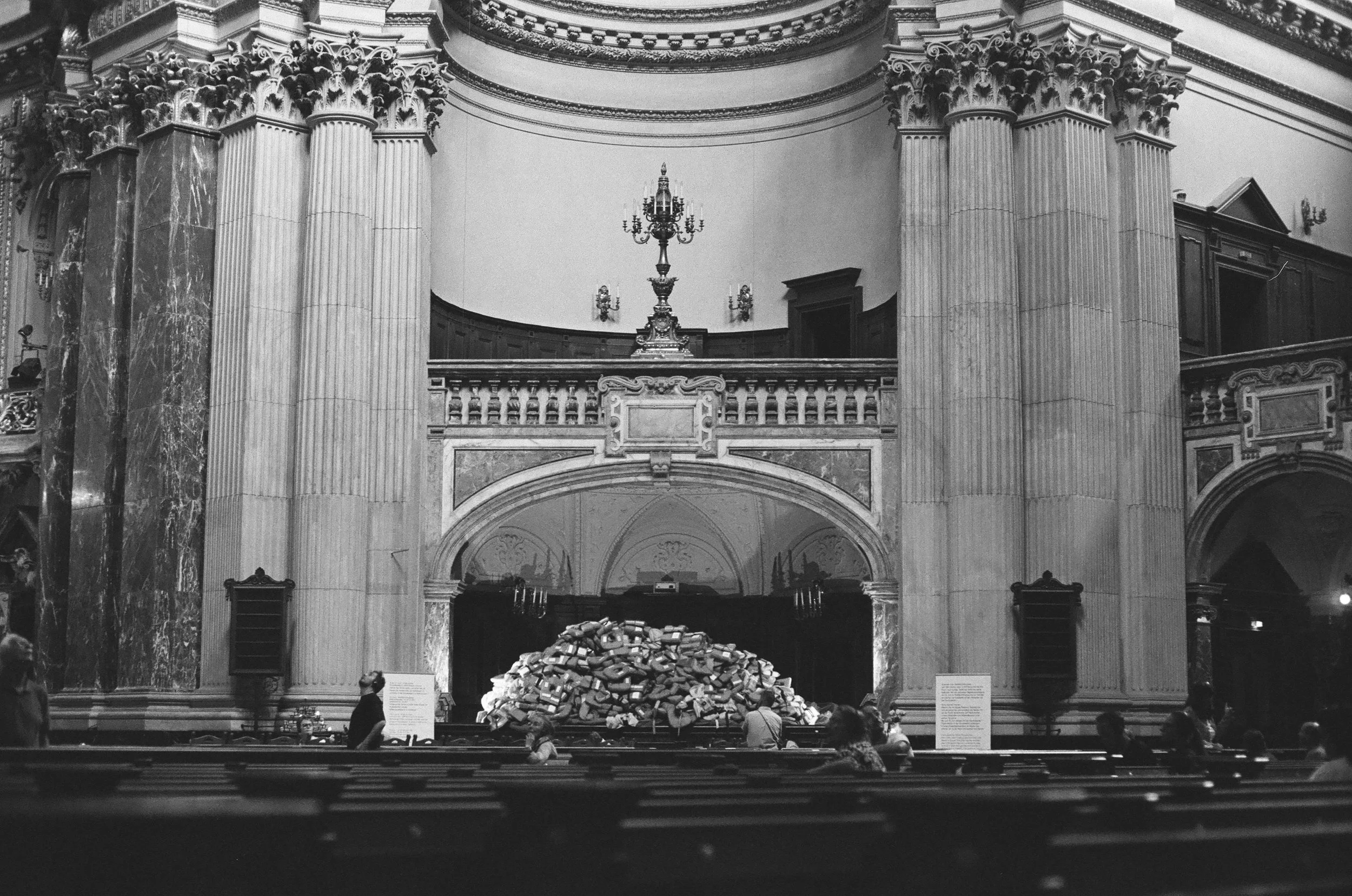 Wide view of the cathedral interior with columns, visitors, and an art installation