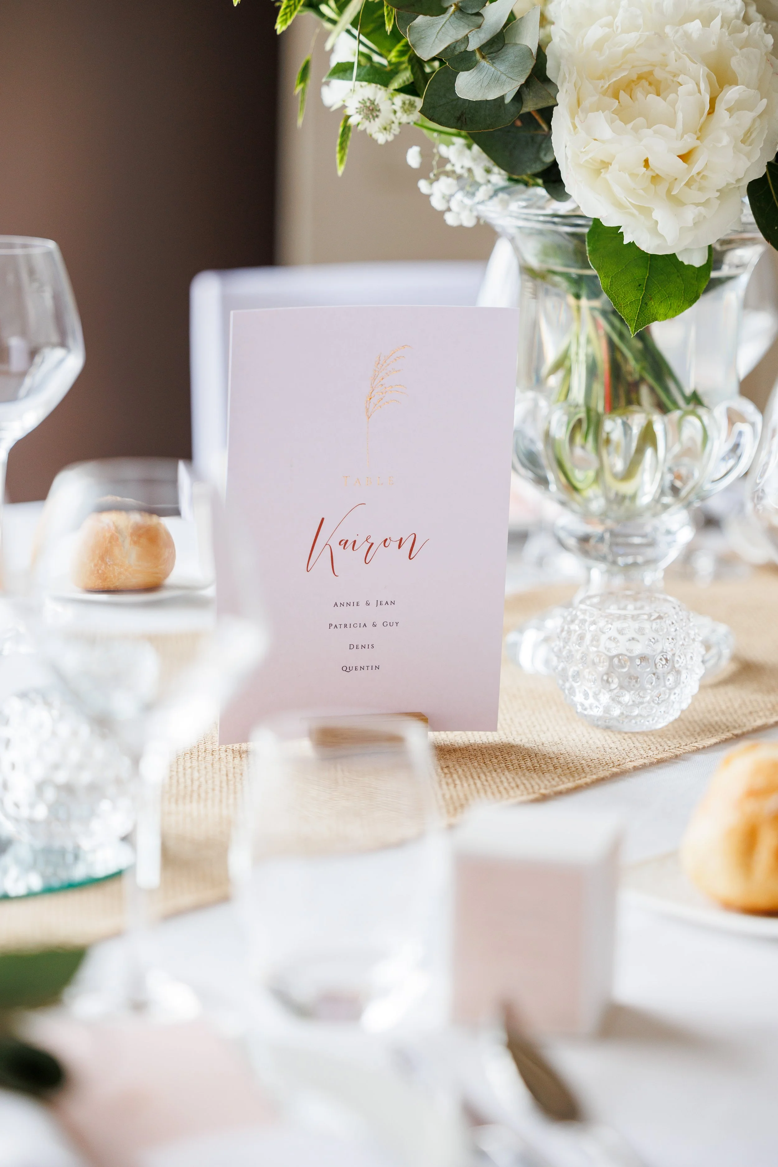 Une table de mariage avec un arrangement floral et un menu élégant.