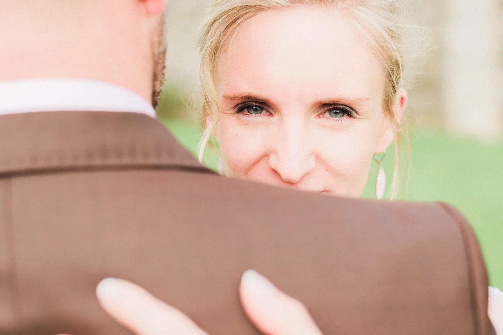Une femme regarde un homme, vue partielle de derrière, lors d'un mariage ou d'une rencontre intime.